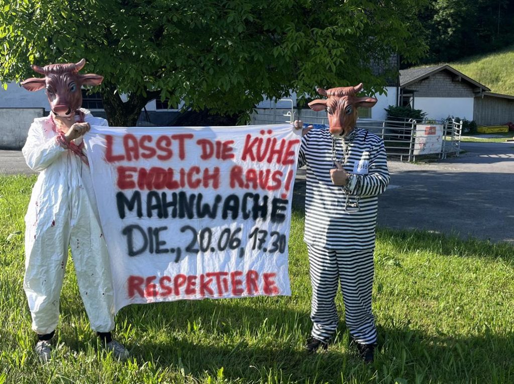 Aktivisten in Kuhmasken vor Bauernhof
