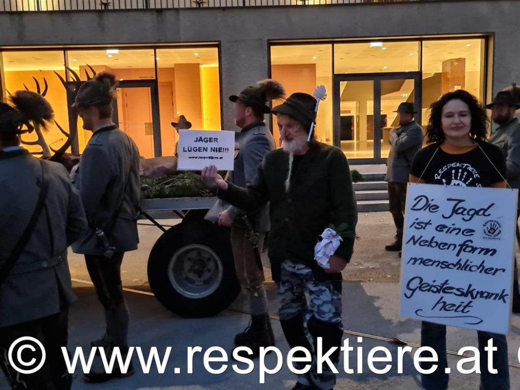 AktivistInnen mit langen Pinoccio-Nasen zeigen Schilder "Jäger lügen nie"